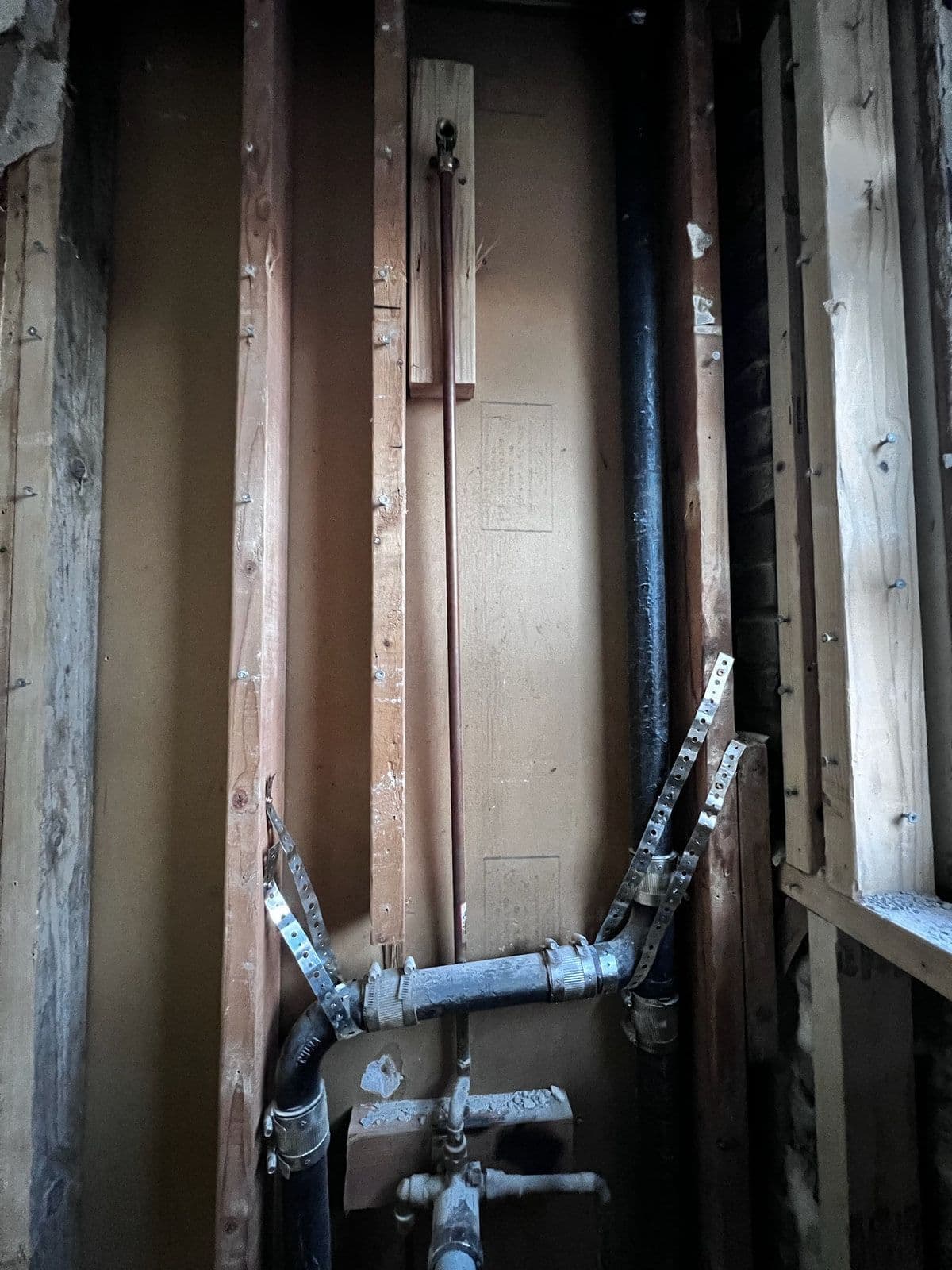 New supply and waste pipework roughed in inside the open wall, before it was closed up.
